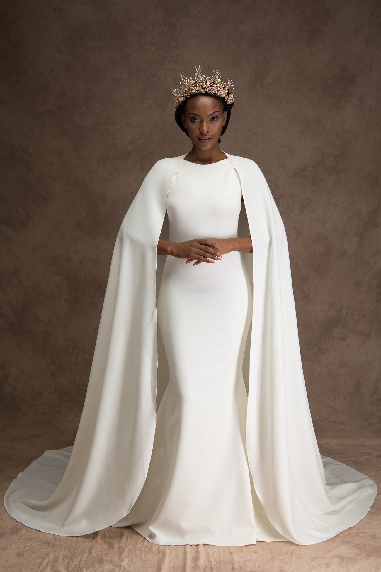 dramatic wedding dress with cape-like floor length sleeves and minimalist fitted bodice
