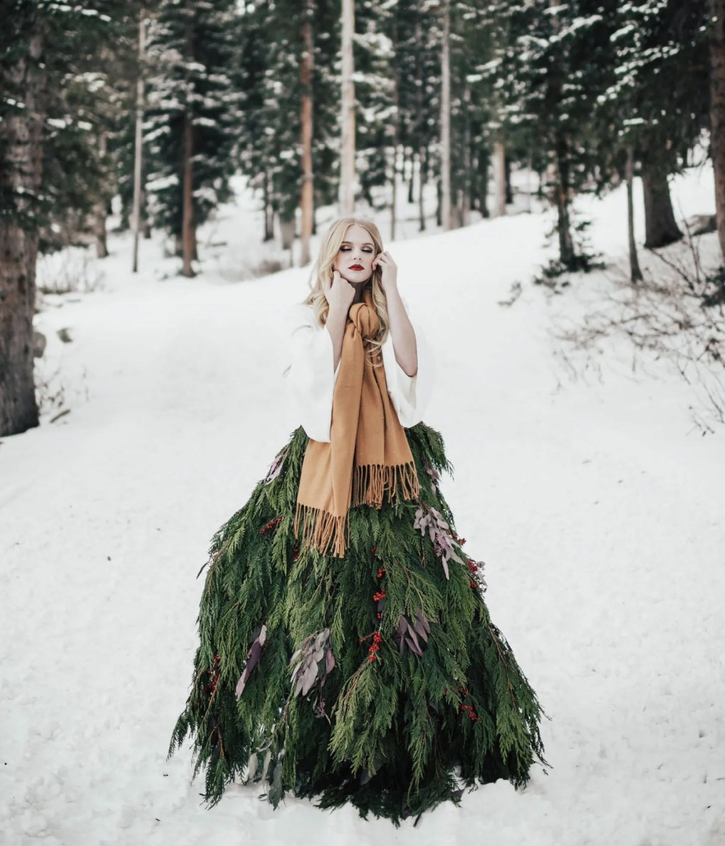bride in a rustic greenery garland skirt while wearing a neutral hued winter scarf in the snow