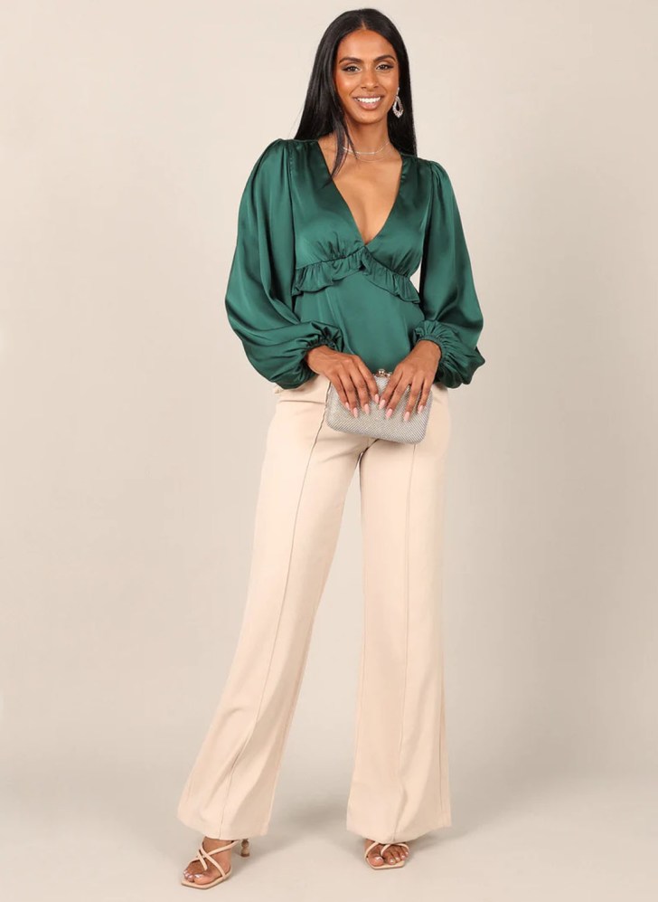 green satin ruffle top and white dress pants best work Christmas party outfits