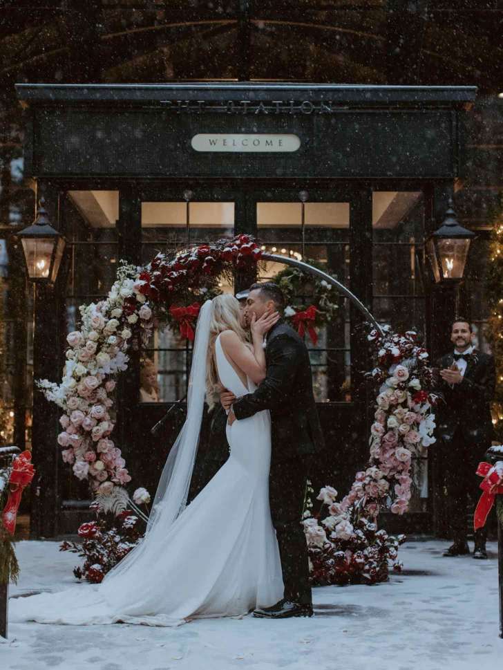 winter wonderland best Christmas wedding ideas where the bride and groom kiss during a snow ceremony